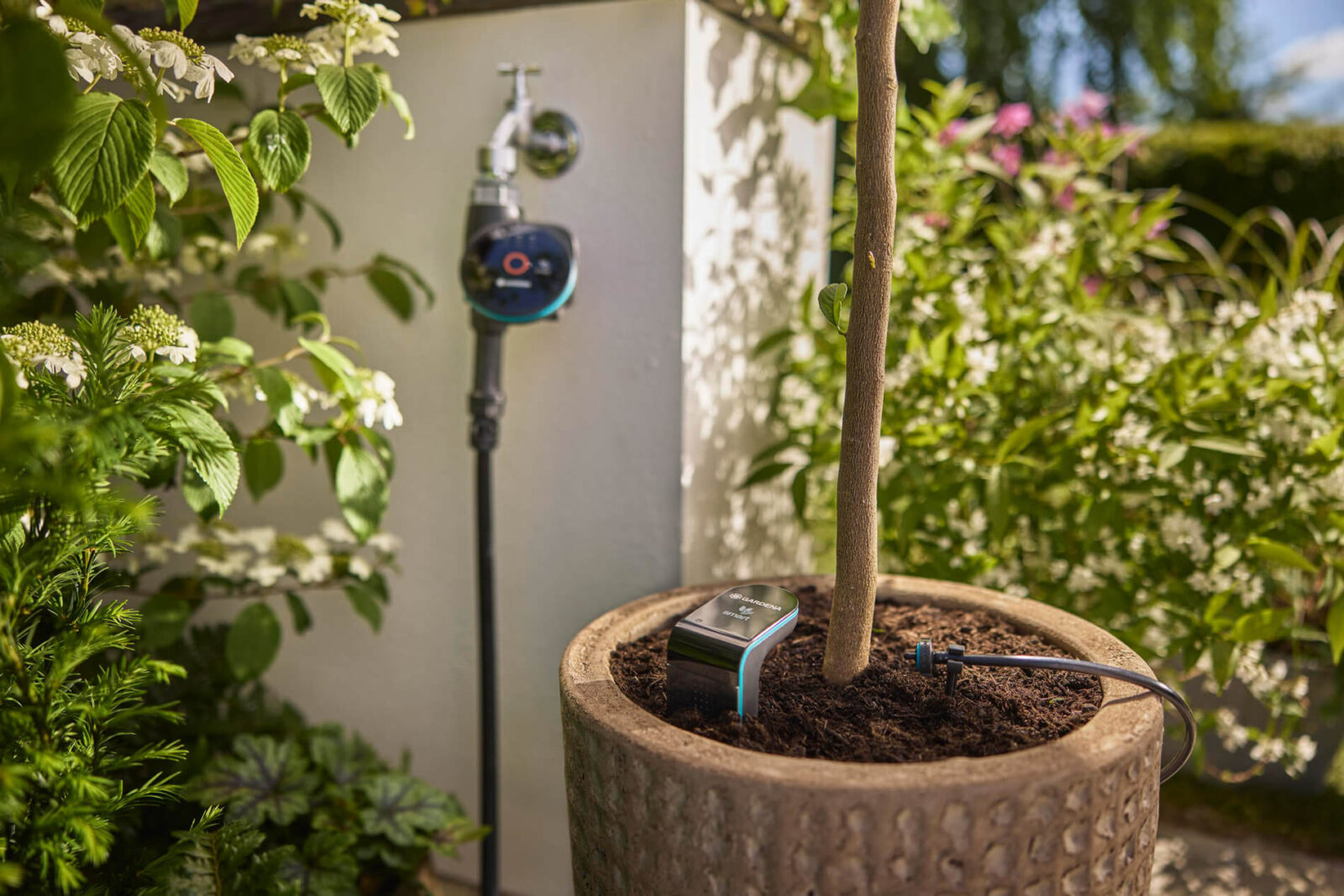Das Wasser fließt nur, wenn die Erde es wirklich braucht: Die Gardena smart Water Control regelt am Hahn die Wassermenge, während der smart Sensor direkt im Kübel die Bodenfeuchte rund um die Pflanze überwacht. (Quelle/Foto: Gardena)